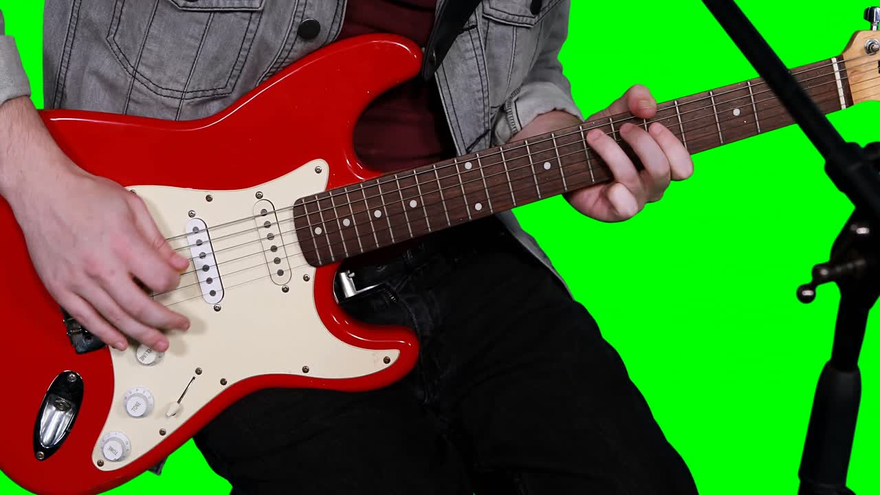 sección media de músico masculino tocando la guitarra