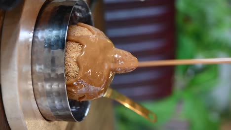 imágenes verticales: vertiendo salsa de caramelo en el postre de la pelota de knafeh, primer plano de knaveh, dulces árabes