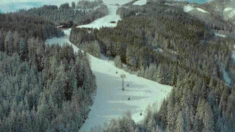 ski trails on snowy mountain slopes at ski resort in austria, aerial