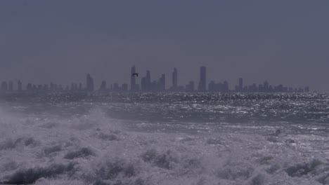surfers in the ocean with powerful waves. rainbow bay in queensland, australia. wide shot
