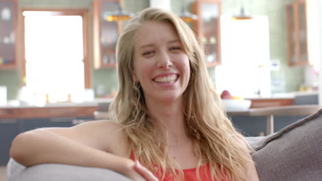 young caucasian woman smiles warmly in a bright home setting