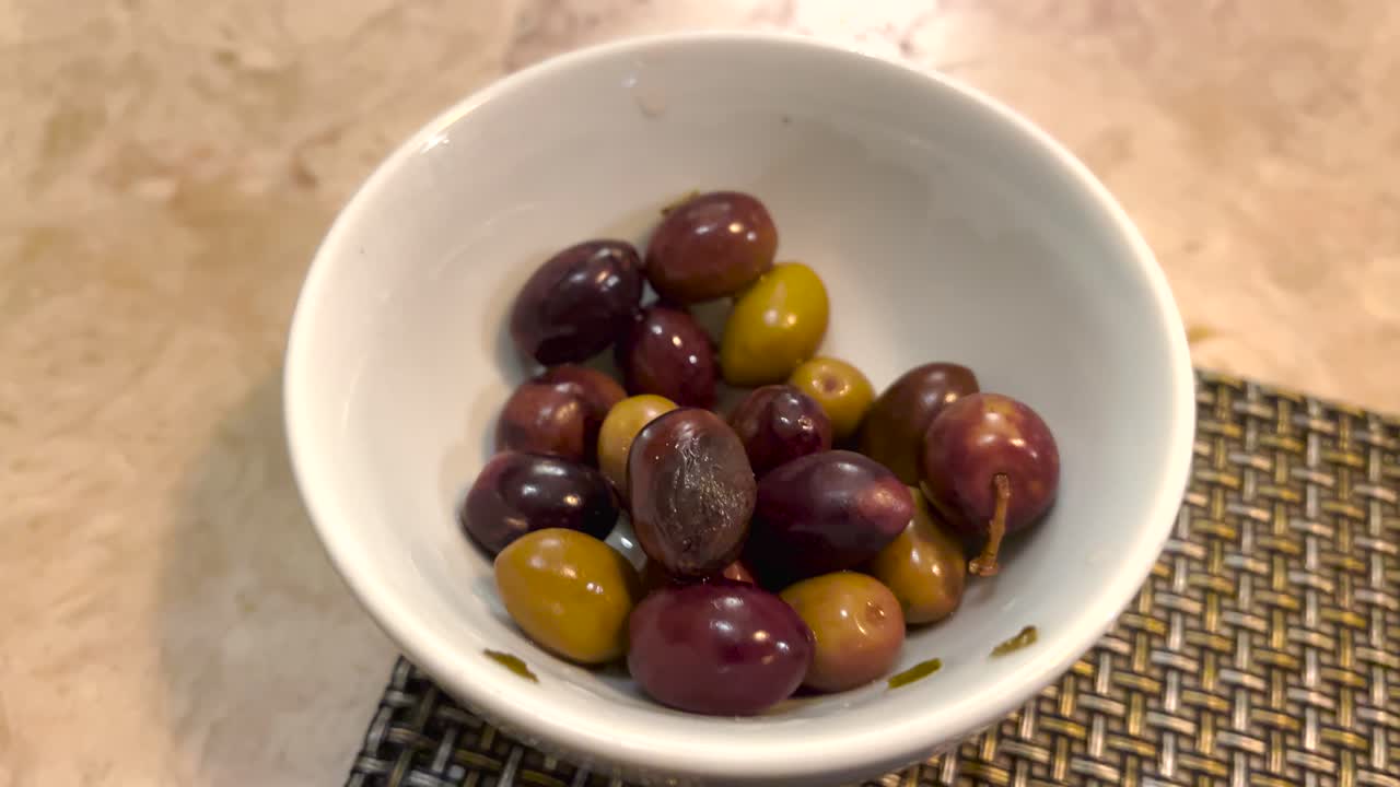 un hombre recogiendo aceitunas a mano y saboreándolas tranquilamente