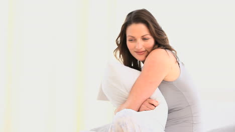 una mujer hermosa abrazando su almohada.