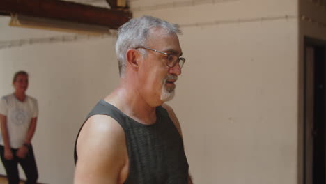 Medium-shot-of-senior-man-having-dance-class-in-studio