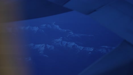 flying above tenerife snow capped mountains at night near teide volcano at night, window view