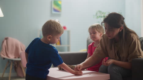 Woman-puts-seeds-into-toddler-son-palm-in-living-room