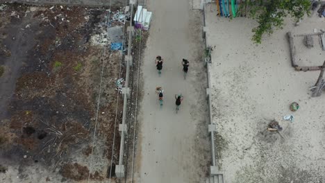 antena de arriba hacia abajo 4 personas montando en bicicleta en un camino de playa en la isla de gili trawangan