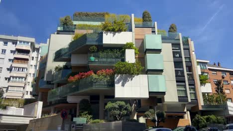 Panning-right-revealing-modern-building-with-terraces-covered-by-plants-in-middle-of-Madrid-city