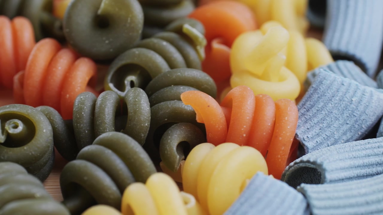 Panoramica ravvicinata di un assortimento di pasta cruda multicolore