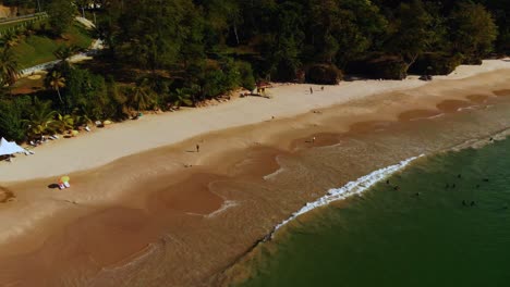 Aerial-footage-of-a-scenic-shoreline-where-the-sea-meets-the-shore-on-this-long-sandy-bbeach