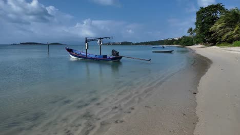 Tranquila-Escena-De-Playa-Con-Un-Barco-Amarrado-En-Las-Aguas-Cristalinas-De-Koh-Samui,-Día-Soleado