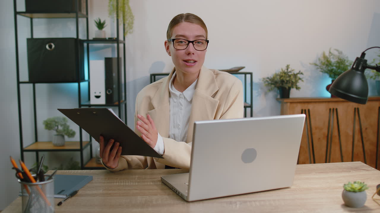 Businesswoman working on laptop at office talk on online communication video call with employee boss