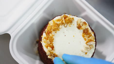 Close-up of a decorated mini chocolate cake in a disposable container