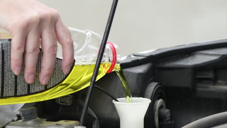 Woman-pouring-windshield-cleaning-liquid-soap-into-car