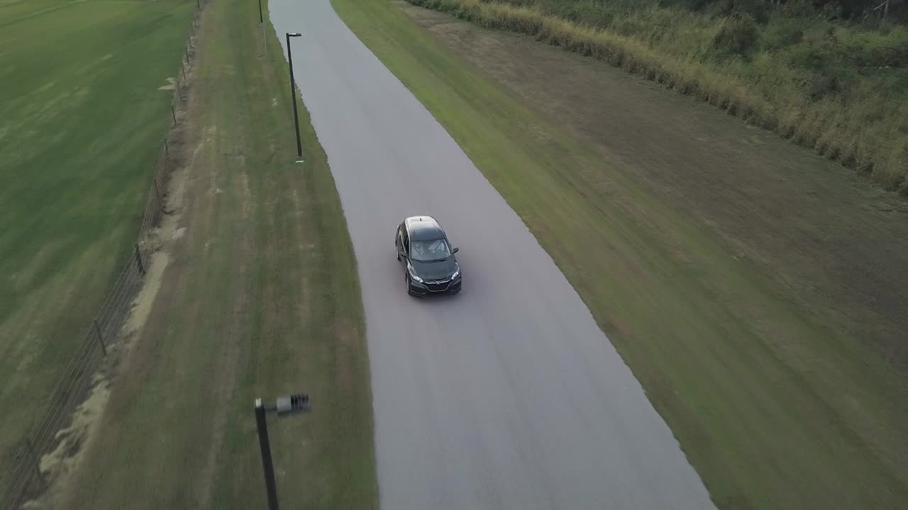 Aerial View of Green Crossover Car Driving Down Empty Country Road
