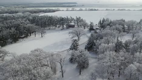 Fliegen-über-Ländliche-Häuser-Und-Schneebedeckte-Felder,-Luft-Nach-Vorne