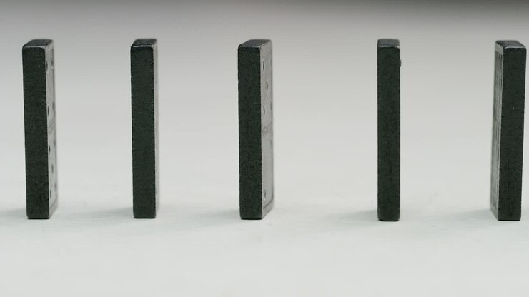 row of black dominoes in a white studio