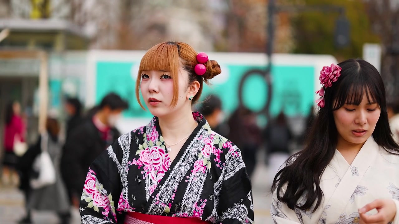 Puolikuva kahdesta yukataan pukeutuneesta naisesta, joilla on kukkakoristeita hiuksissa, Tokiossa, Japanissa.