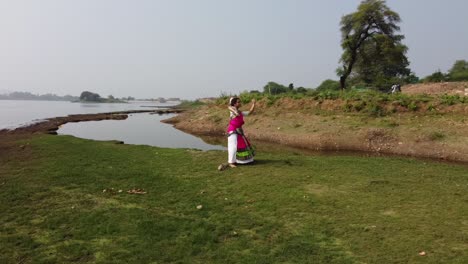 A-bharatnatyam-dancer-displaying-a-classical-bharatnatyam-pose-in-the-nature-of-Vadatalav-lake,-Pavagadh