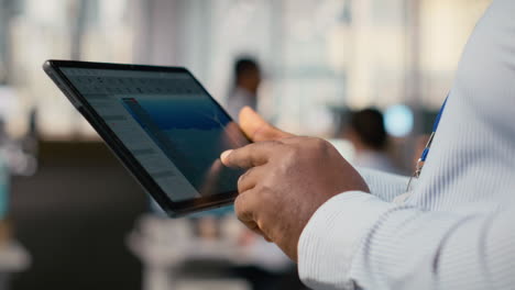 close up of engineer in office using tablet to work on wind turbine cad design