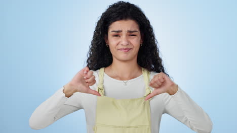 Thumbs-down,-face-and-woman-in-studio-with-hands