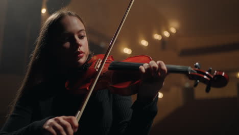 la dama bonita está tocando el violín en la escena de la casa de la ópera concierto de música clásica en la sala filarmónica