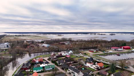 Después-De-Las-Inundaciones-Invernales-En-Las-Afueras-De-La-Ciudad-De-Silute-Lituania,-El-Agua-Tranquila-Refleja-El-Cielo-Y-Los-árboles-Sin-Hojas