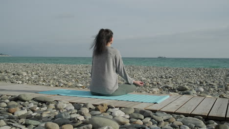 mujer meditando en una playa