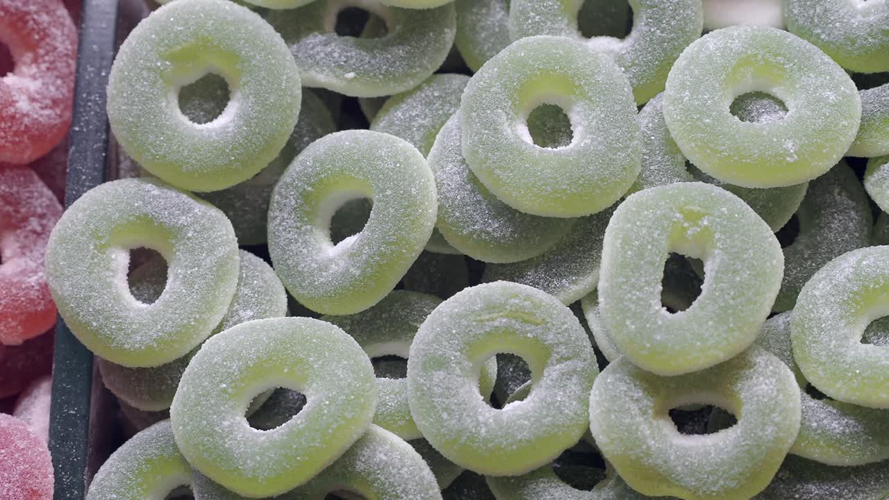 Vibrantes Caramelos de Goma en Forma de Anillo Cubiertos de Azúcar Verdes y Rojos