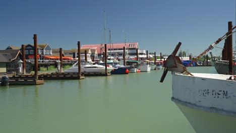 slow side to side pan focusing on the variety of boats moored up in small fishing town steveston, british columbia, canada on a sunny summer day