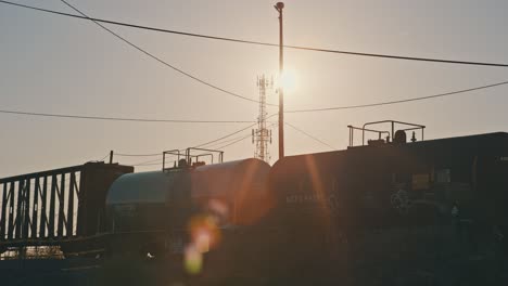 freight train cargo moving in slow motion during golden hour with sun flares cinematic