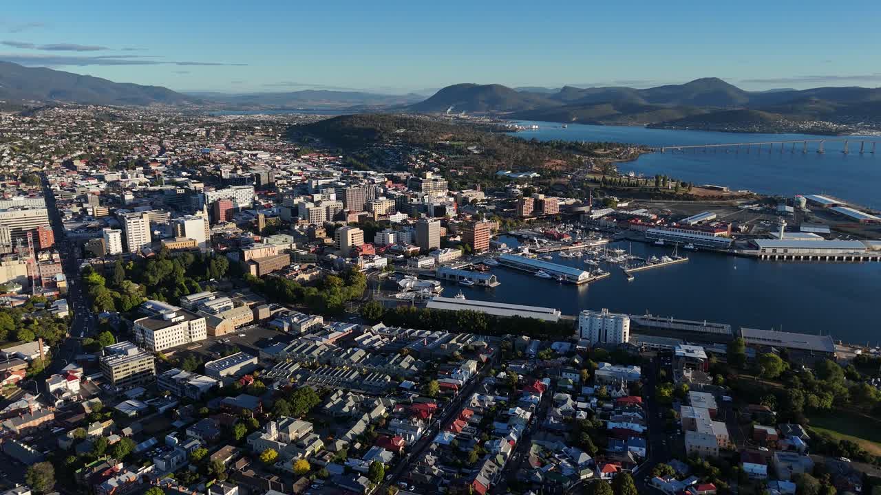 Harbor of Hobart city with mountains in background in Tasmania, drone shot tilting
