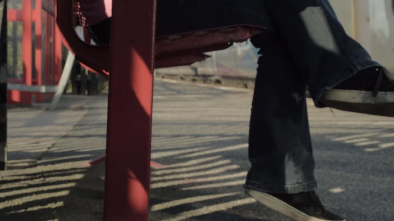 기차가 중간 샷으로 지나갈 때 기차 플랫폼 좌석의 다리