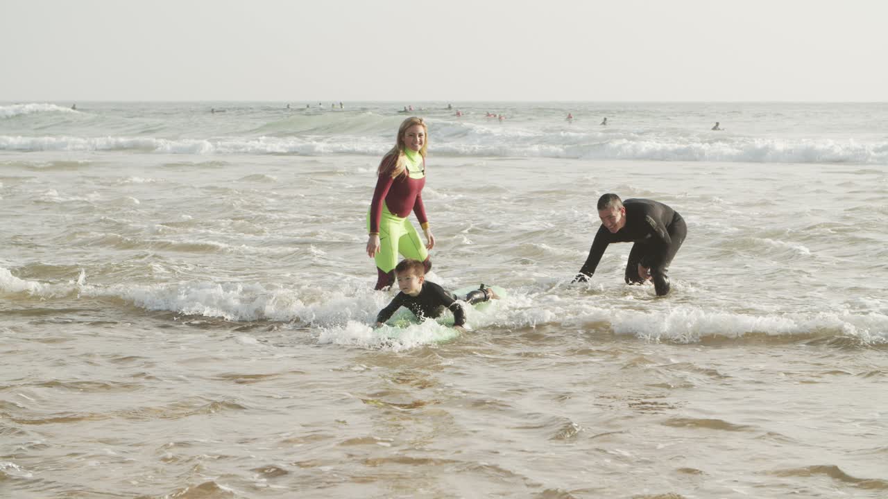 родители смотрят, как сын плавает на борту.