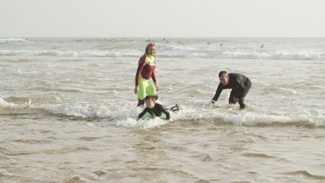 parents looking at son swimming on board