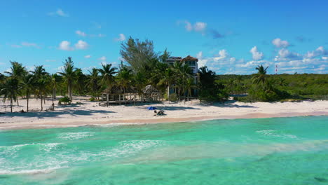 aerial-landscape-of-tropical-white-sand-beachfront-house-on-sunny-day-with-turquoise-water-in-Playa-Del-Carmen-Mexico