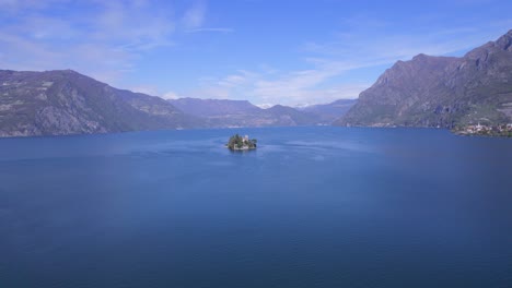 drone approaching from distant to loreto small and tiny island in iseo lake