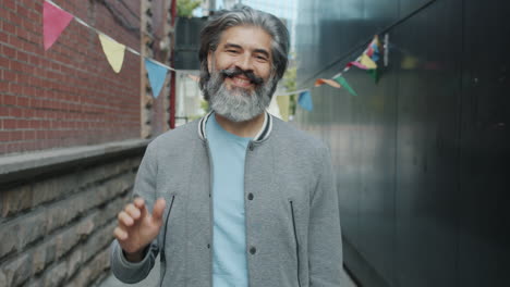 friendly man waving in an urban alley
