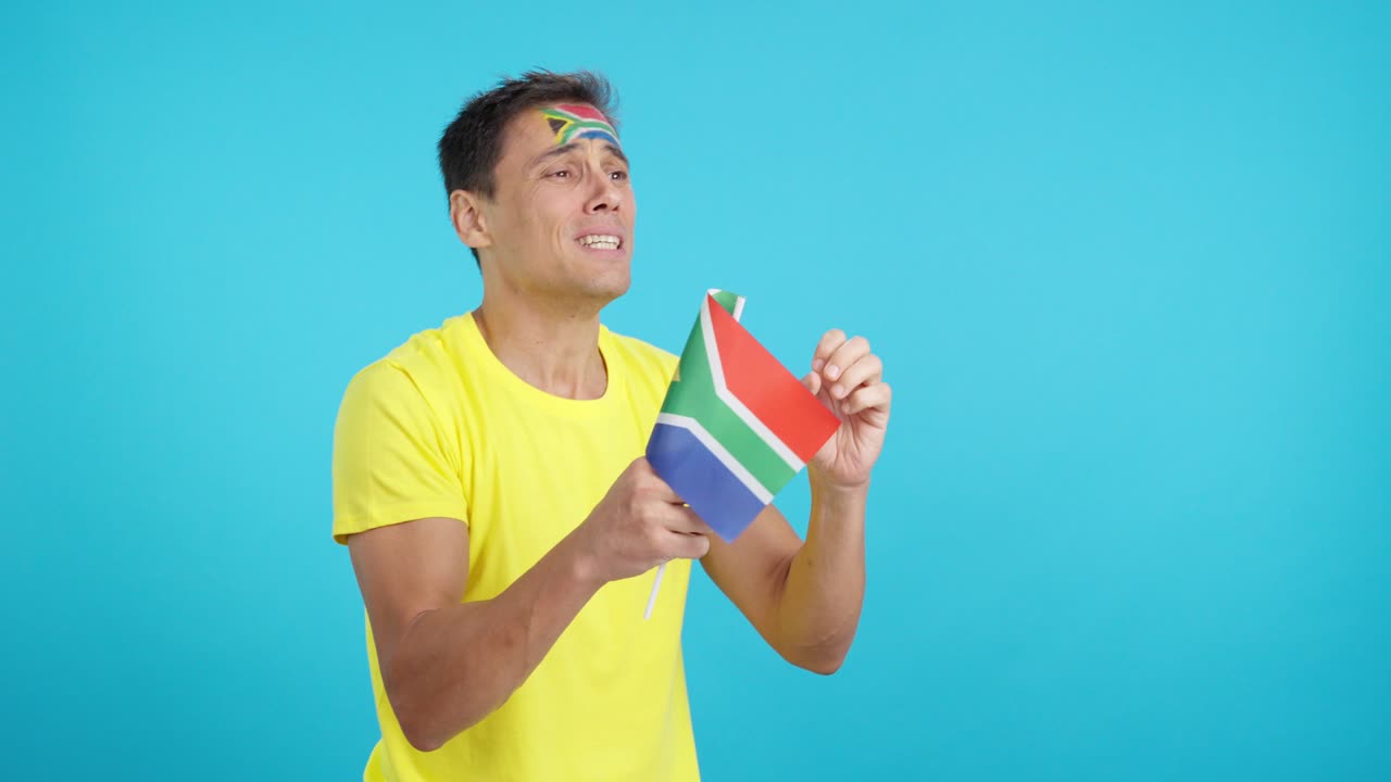 Nervous man cheering for South Africa during a match looking away