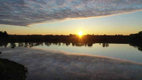 el amanecer o el atardecer sobre un lago tranquilo