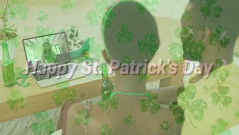 Happy-st-patricks-day-text-and-clover-leaves-against-couple-having-video-call-on-laptop-at-home