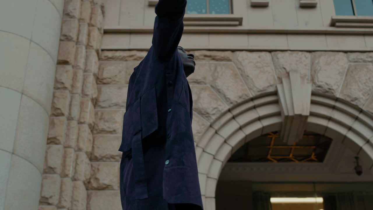 Man Expressing Freedom in Front of Building