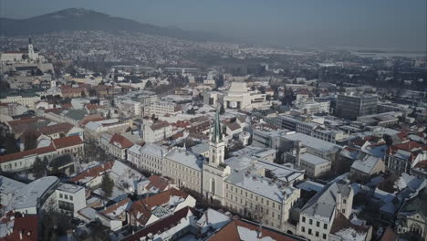 Toma-Aérea-Amplia-De-La-Ciudad-De-Nitra-Con-Castillo-Y-Montañas-En-El-Fondo,-Invierno,-Eslovaquia