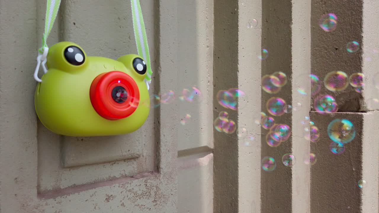 Static close-up of frog-shaped toy emitting bubbles on a sunny day in Oaxaca