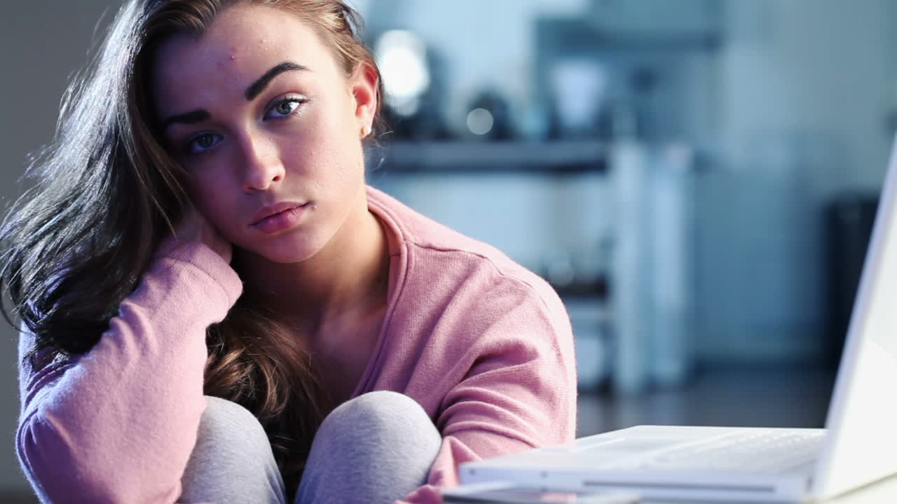 Sad depressed teenage girl using cell phone