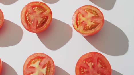 video de tomates rojos recién cortados por la mitad sobre un fondo blanco