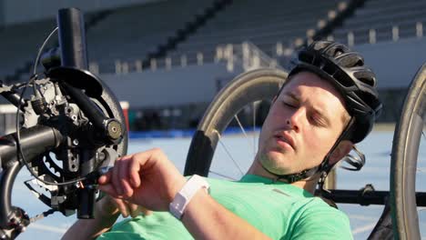 disabled athlete using smartwatch on a running track 4k