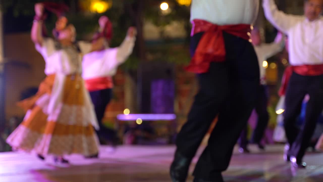 poca profundidad de campo que muestra a un hombre y una mujer haciendo danza mexicana en segundo plano