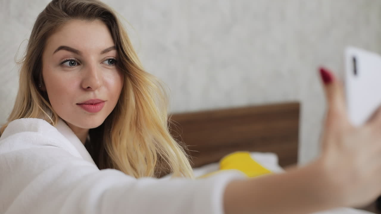 una mujer tomando una selfie en un dormitorio.