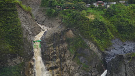 Zeitlupenaufnahme-Eines-Gigantischen-Wasserfalls-Und-Einer-Seilbahn-Mit-Einem-Kleinen-Dorf-In-Den-Dschungelbergen-Von-Ecuador